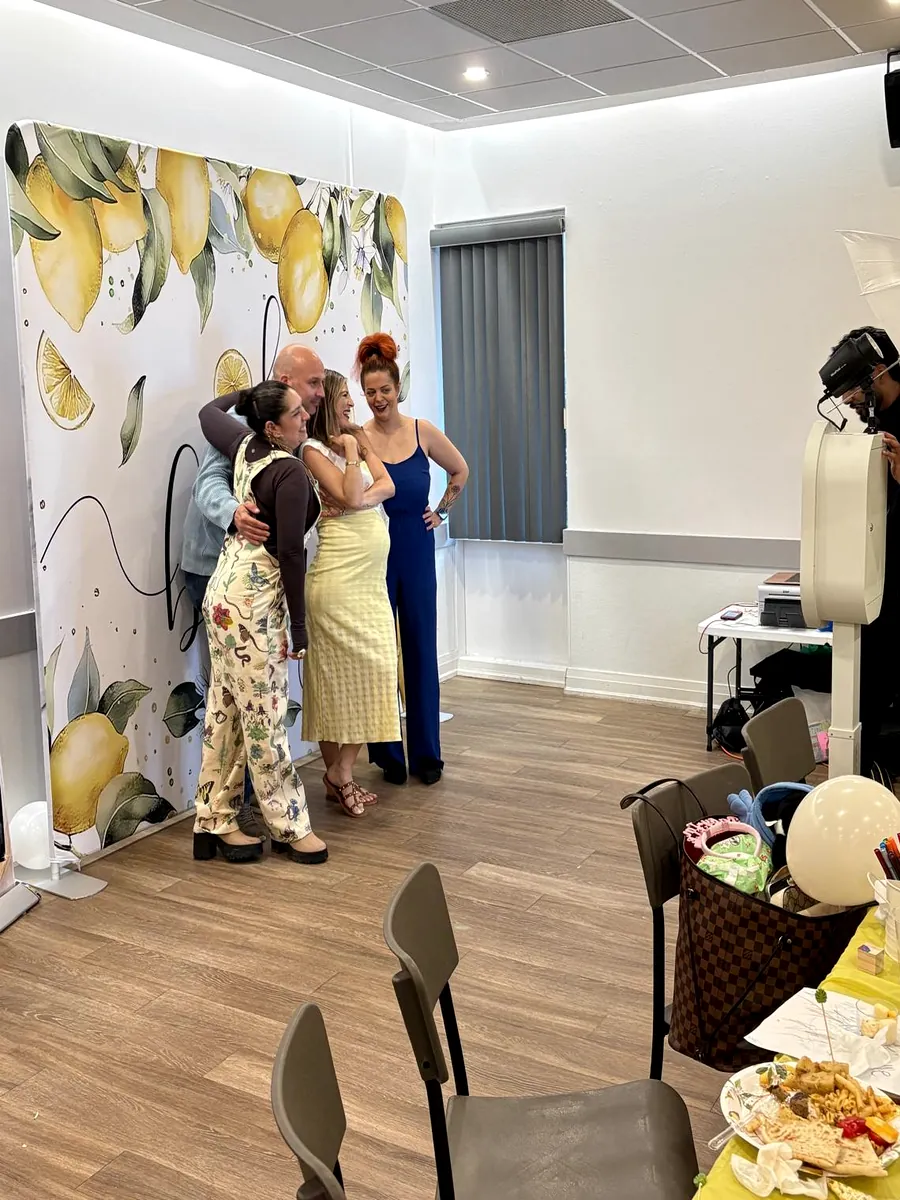 Guests posing at a baby shower photo booth